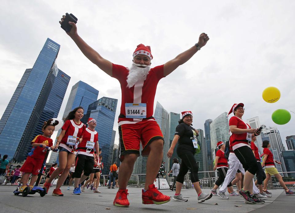 A participant reacts to the camera as they start the Santa Run for Wishes charity run along the Marina Promenade in Singapore REUTERS/Edgar Su (SINGAPORE - Tags: SPORT ATHLETICS SOCIETY)