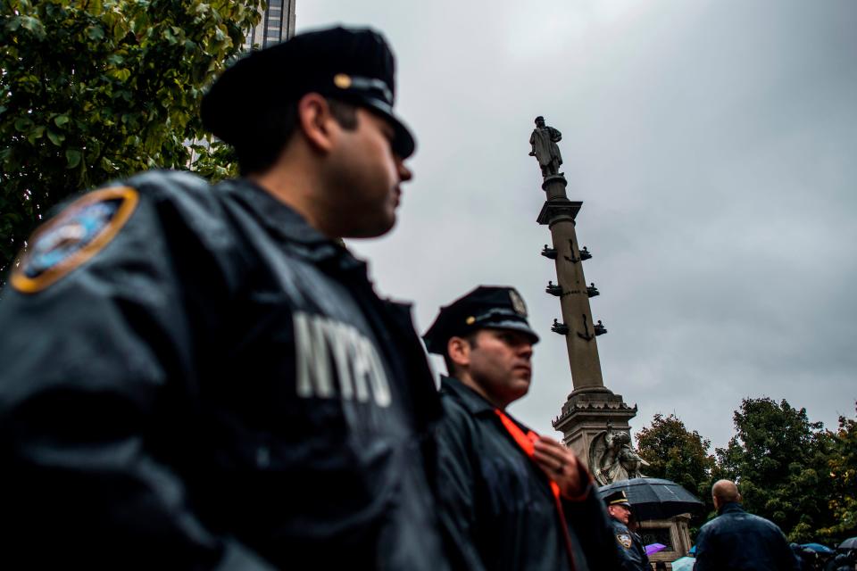 New York Police Department officers stand alert near the statue of Christopher Columbus at Columbus Circle in New York on October 9, 2017, during a protest.