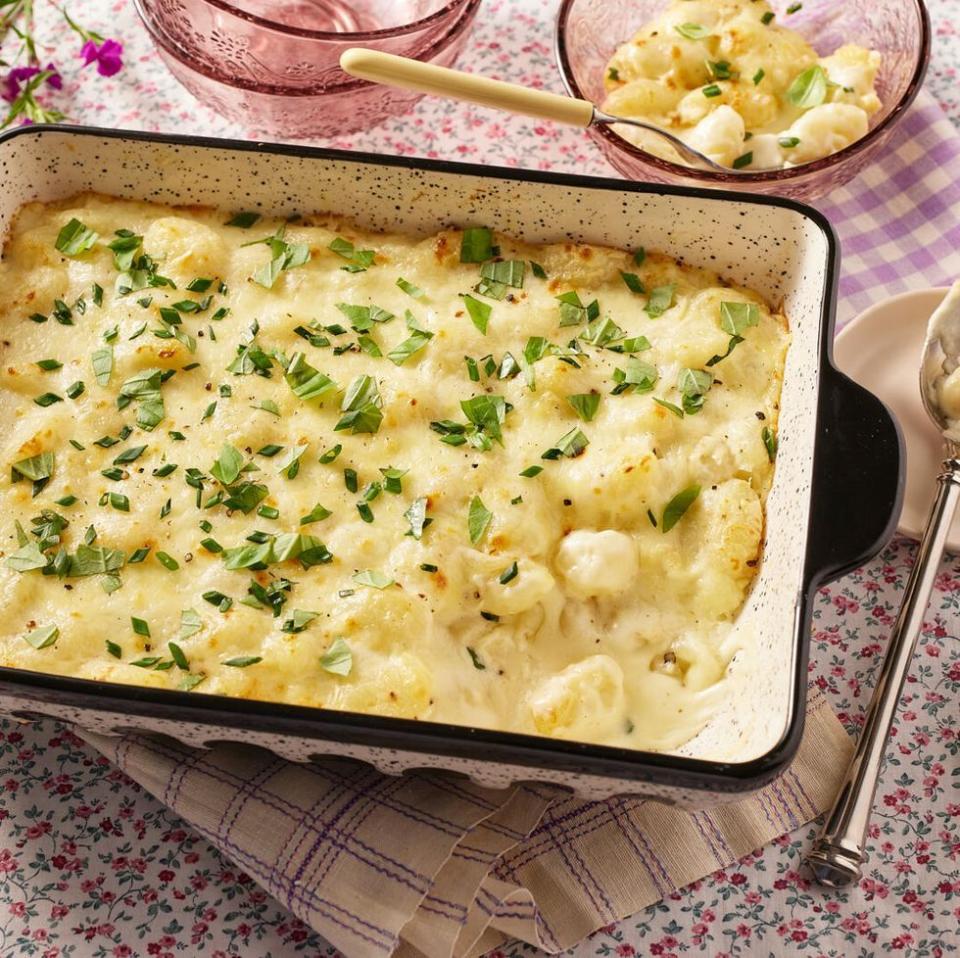 baked gnocchi alfredo with basil in black and white dish