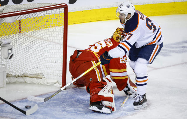 Edmonton Oilers center Connor McDavid, right, scores on Calgary Flames goalie Jacob Markstrom during the second period of Game 2 of an NHL hockey Stanley Cup playoffs second-round series Friday, May 20, 2022, in Calgary, Alberta. (Jeff McIntosh/The Canadian Press via AP)