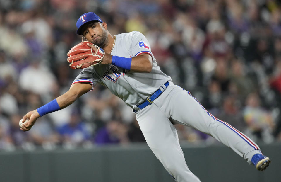 Texas Rangers third baseman Ezequiel Duran throws to first base on an infield single hit by Colorado Rockies' Randal Grichuk in the eighth inning of a baseball game Tuesday, Aug. 23, 2022, in Denver. (AP Photo/David Zalubowski)
