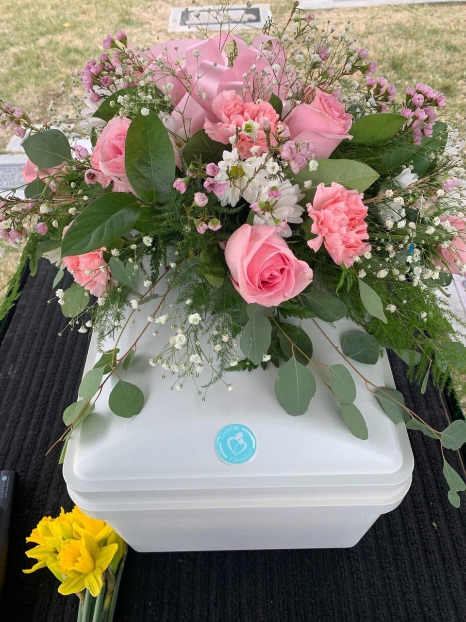 Flowers sit on the casket for Baby Girl Doe at the graveside service.