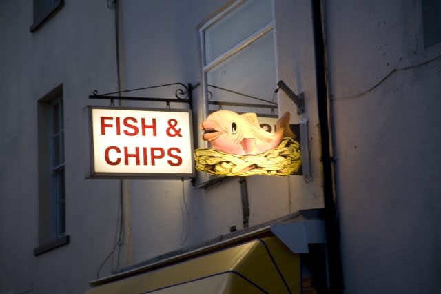 Fish and chip shop sign illuminated at night, Harwich, Essex