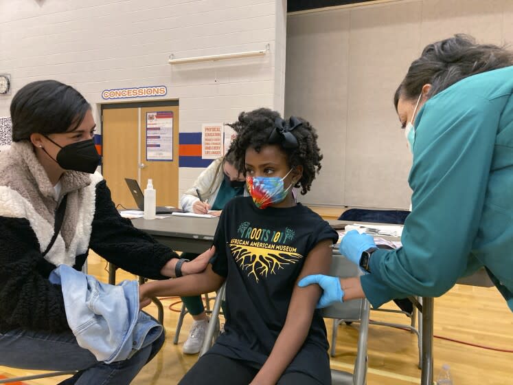 Cadell Walker comforts her daughter Solome, 9, as nurse Cindy Haskins administers a Pfizer COVID-19 shot at a vaccination clinic for young students at Ramsey Middle School on Saturday, Nov. 13, 2021 in Louisville, Ky. Scientists say vaccinating kids against COVID-19 should not only slow the spread of the coronavirus but also help prevent potentially-dangerous variants from emerging. Each new infection brings another opportunity for the virus to mutate and evolve dangerous new traits. (AP Photo/Laura Ungar)
