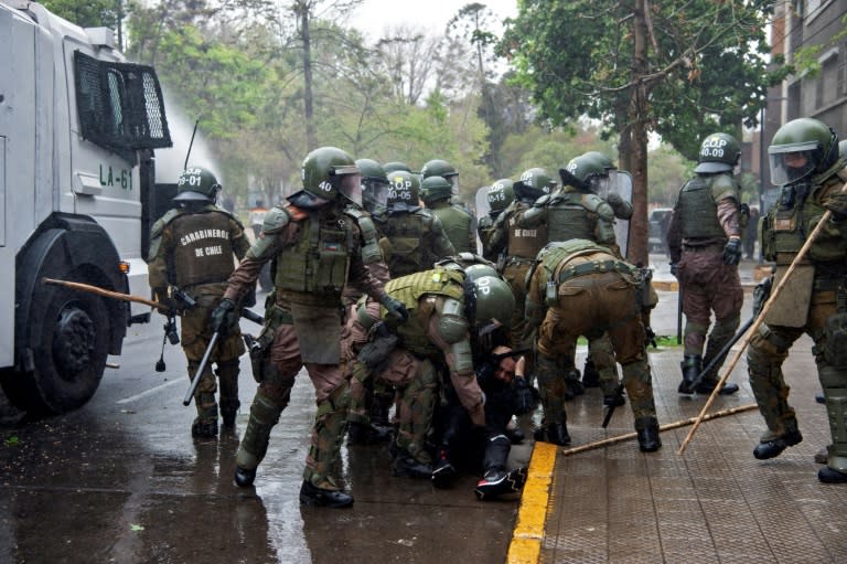 Policías antidisturbios arrestan a un manifestante en los enfrentamientos durante una protesta de indígenas mapuches, el 10 de octubre de 2021 en el centro de Santiago de Chile (Martín Bernetti)