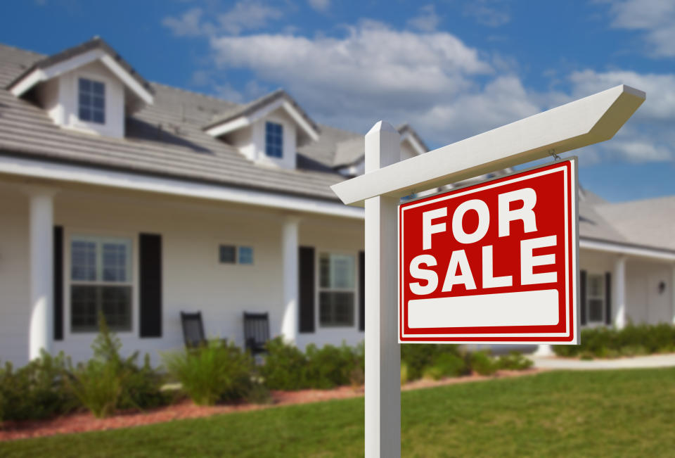 A "For Sale" sign in front of a residential house