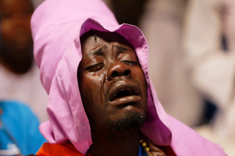 A faithful reacts in prayers during a mass amid concerns about the spread of coronavirus disease (COVID-19) at the St. Joanes, Legio Maria African Mission Church within Fort Jesus in Kibera slums of Nairobi