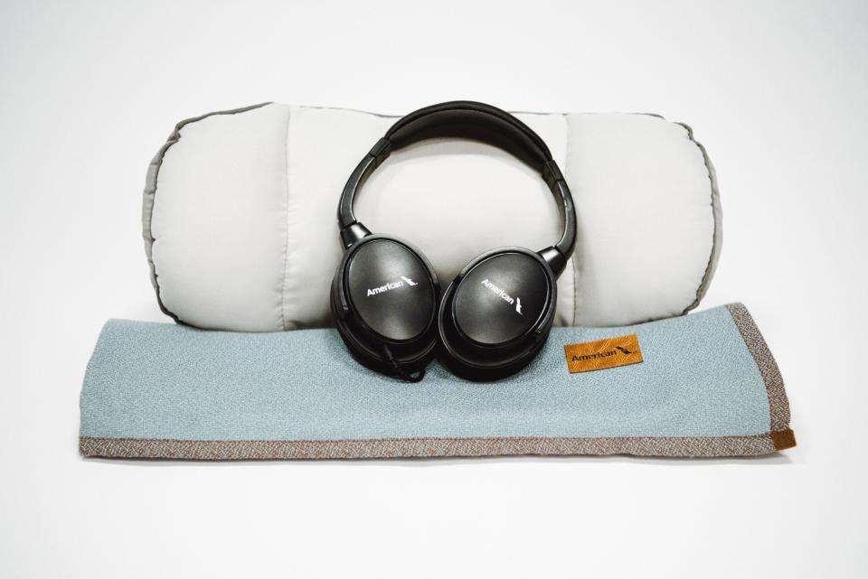 Premium economy new amenities at American, headphones, pillow, blue blanket