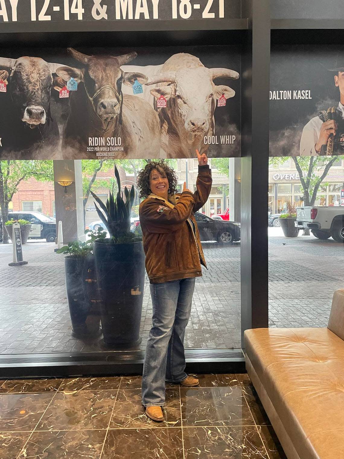 Wichita native Staci Addison poses in front of a sign promoting her bull, Cool Whip, on the Unleash the Beast Tour on PBR.