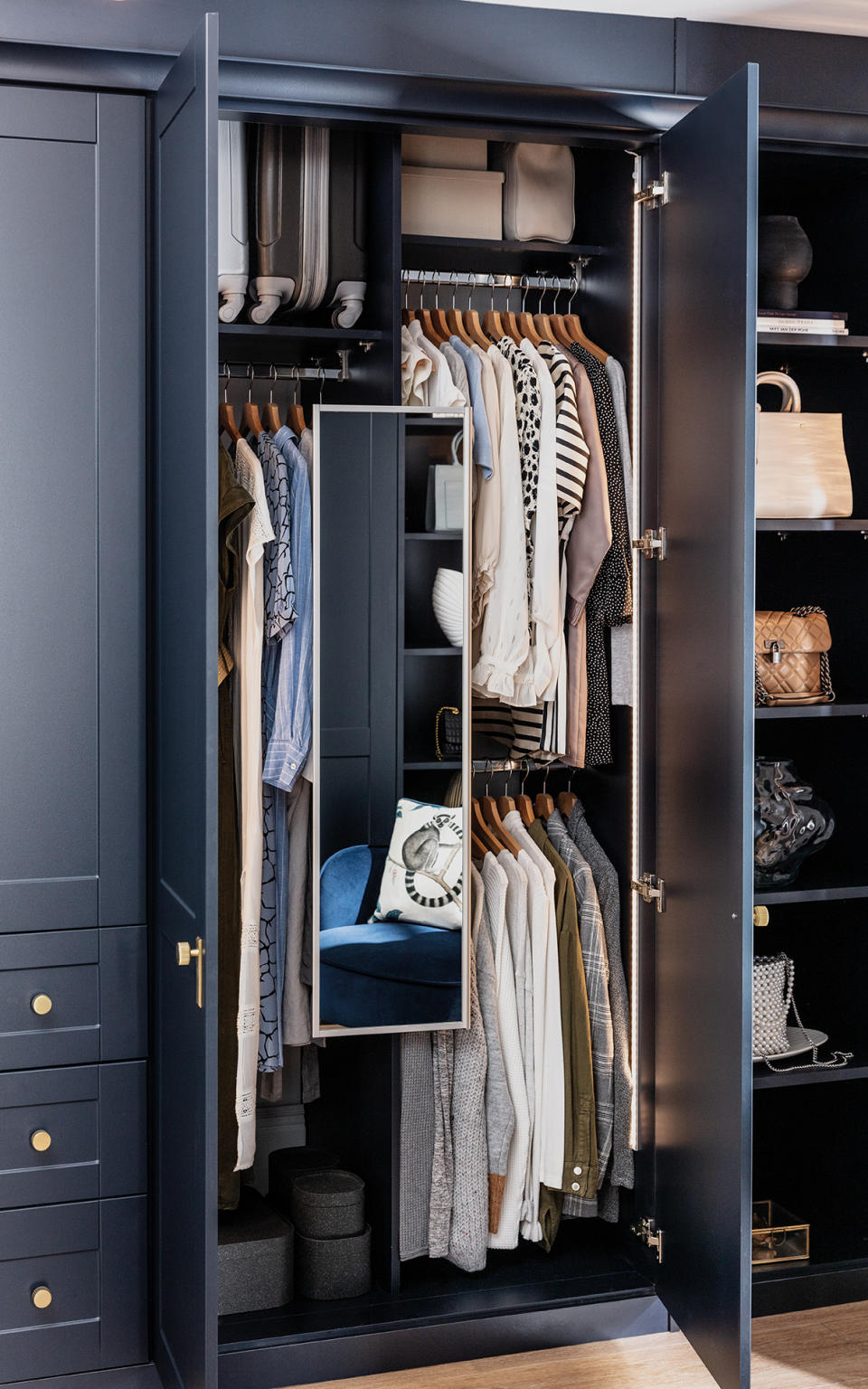 small clothing storage closet with hanging space, shelving, mirror