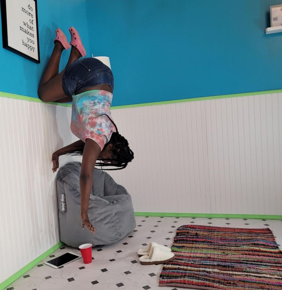 Terajai Brown, 12, formerly of Madison and now living in Princeton, Texas, poses for a photo in a 'room on its side' at Pose Selfie World in Flowood where customers can use props and backgrounds to create eye-catching selfies.