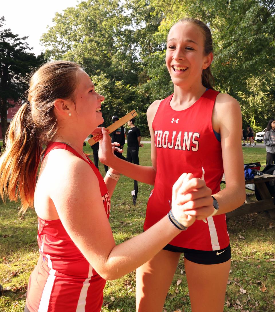 Bridgewater-Raynham's Camden Strandberg, 15, right, won the girls cross country meet versus Brockton and was congratulated at the finish line at the Natural Trust in Easton on Wednesday, Sept. 27, 2023.