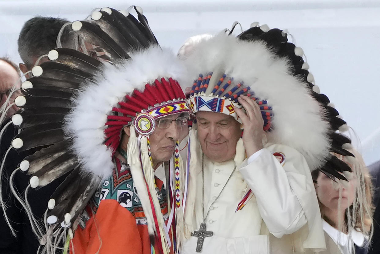 Pope Francis puts on an Indigenous headdress during a meeting with Indigenous communities, including First Nations, Metis and Inuit, at Our Lady of Seven Sorrows Catholic Church in Maskwacis. 