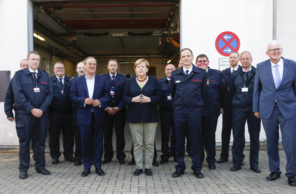 German Chancellor Angela Merkel and North Rhine-Westphalia's State Premier, chairman of the Christian Democratic Union party and candidate for Chancellery Armin Laschet, center left, visit the fire station in Schalksmuehle, Germany, Sunday Sept. 5, 2021. (Thilo Schmuelgen/Pool via AP)