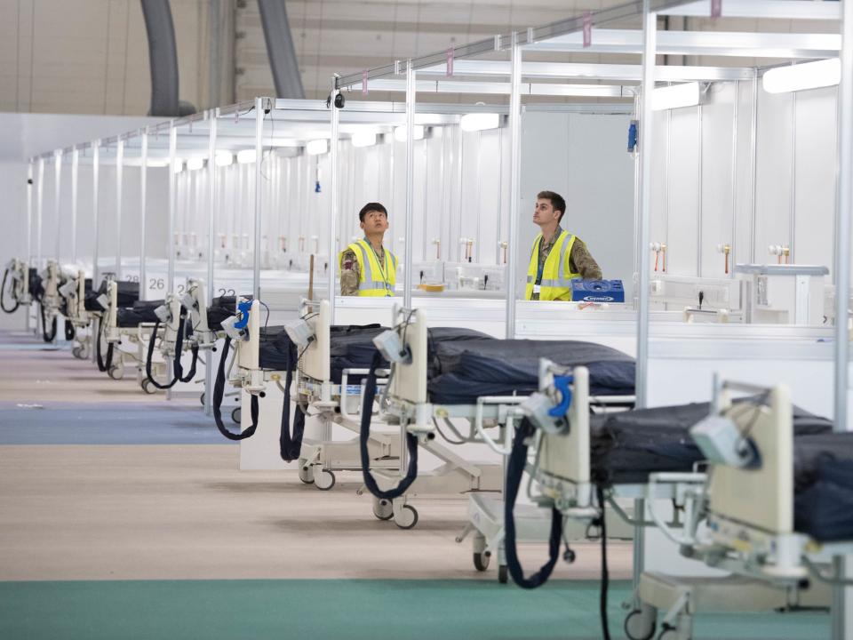 Soldiers and private contractors help to prepare the ExCel centre which is being made into the temporary NHS Nightingale hospital.