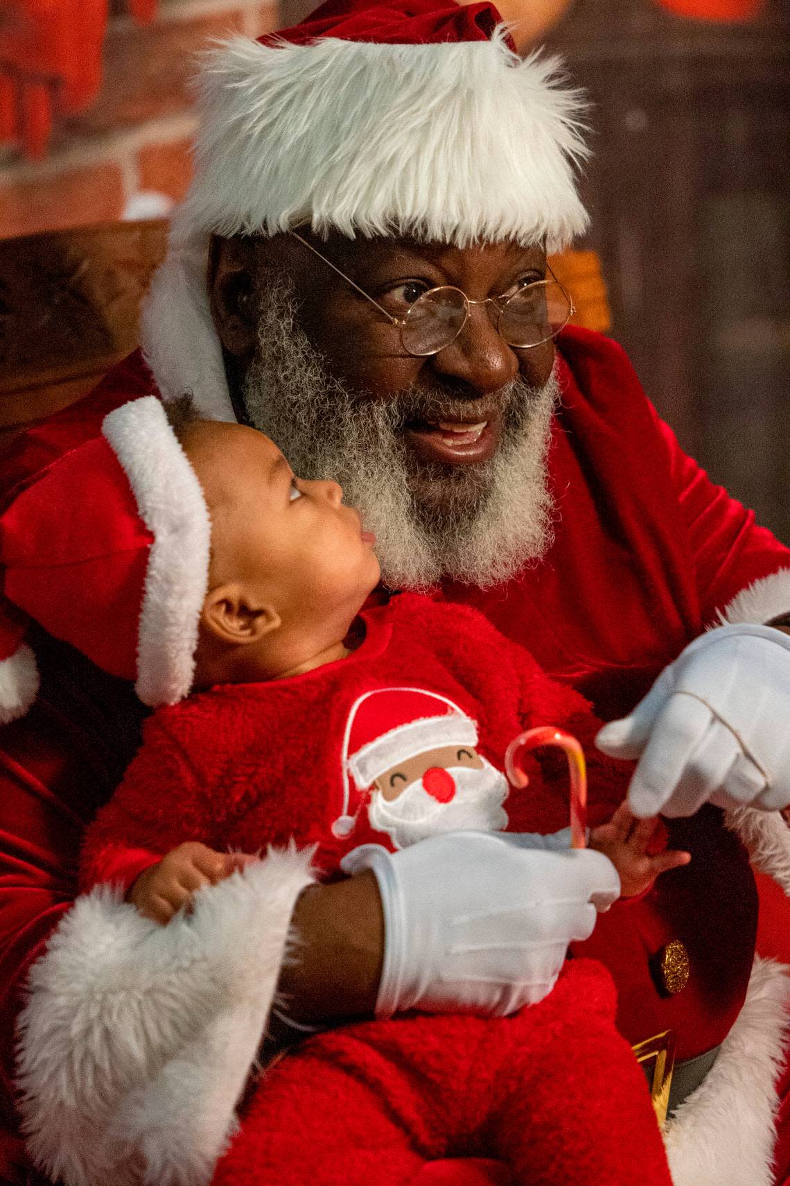 Nine-month-old Greyson Hayes has his photograph taken with Santa Claus, aka Joe Griffin or Santa Joe, at the Hayti Center in Durham Wednesday, Dec. 21, 2022.