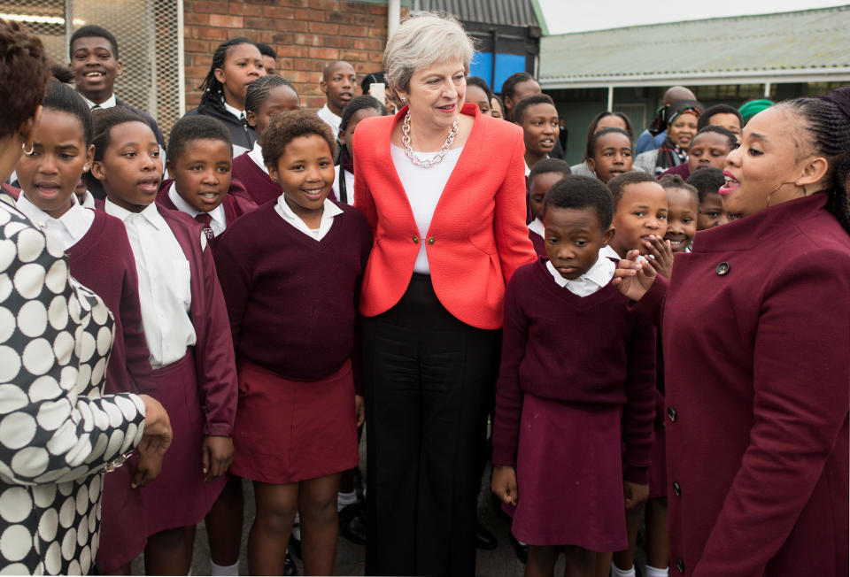 Theresa May poses for a picture with school children during a visit to the ID Mkhize Secondary School in Gugulethu near Cape Town (Reuters)
