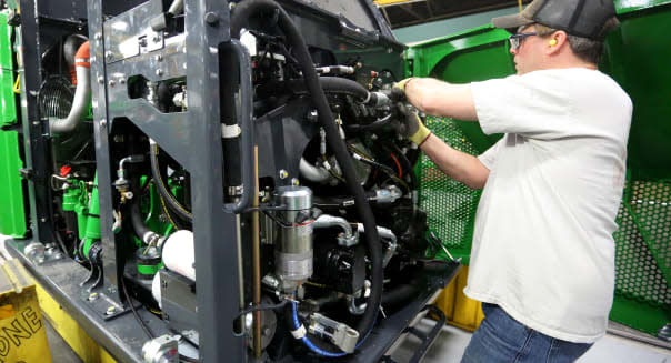 FILE - In this Feb. 11, 2015, file photo, Mark Moriarty works on a John Deere Tracked Feller Buncher/Harvester at John Deere Dubuque Works in Dubuque, Iowa. The Commerce Department reports on U.S. factory orders for June 2015 on Tuesday, Aug. 4, 2015. (Jessica Reilly/Telegraph Herald via AP) MANDATORY CREDIT