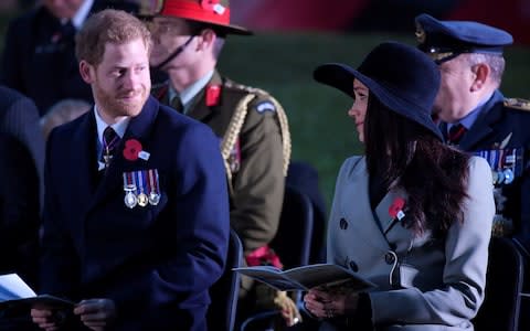 Prince Harry and Meghan Markle share a glance at the dawn service - Credit: TOBY MELVILLE /Reuters