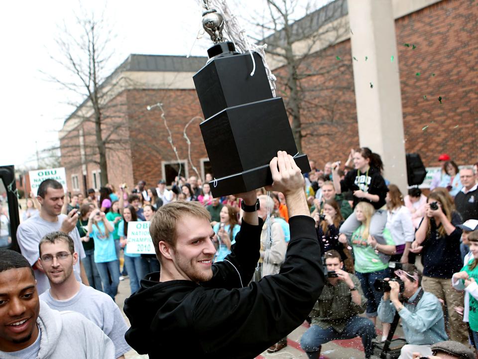 Oklahoma Baptist University's captain Tyler Parker, a senior, holds up the team's 2010 championship trophy in front of fans as he and his teammates celebrate the team's NAIA Championship as they arrive at Noble Complex on the OBU campus in Shawnee.
