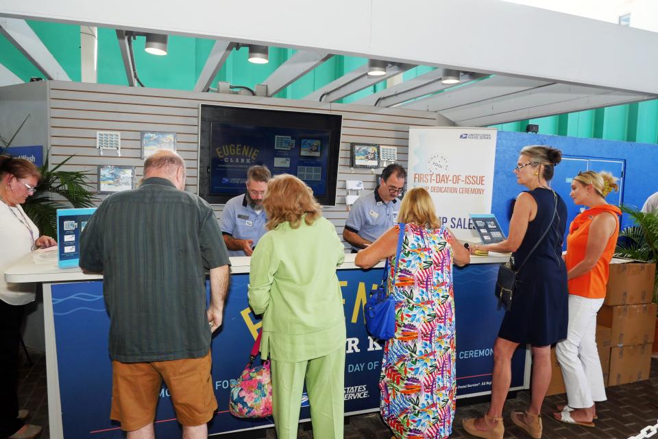 Patrons at Mote Marine Laboratory & Aquarium line up to purchase Eugenie Clark Forever stamps and First Day covers at a U.S. Post Office station set up in the aquarium courtyard on Wednesday.