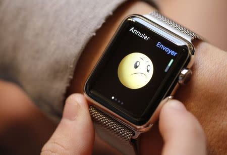 A customer tries on an Apple Watch at an Apple Store in Paris April 10, 2015. REUTERS/Christian Hartmann