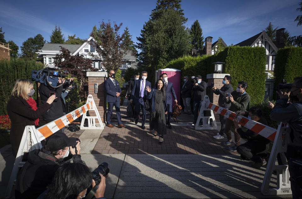 Meng Wanzhou, chief financial officer of Huawei, waves as she leaves her home in Vancouver, on Friday, Sept. 24, 2021. U.S. prosecutors are prepared to resolve criminal charges against the chief financial officer of Chinese communications giant Huawei Technologies, the Justice Department disclosed Friday in a letter to a federal judge in New York. (Darryl Dyck/The Canadian Press via AP)