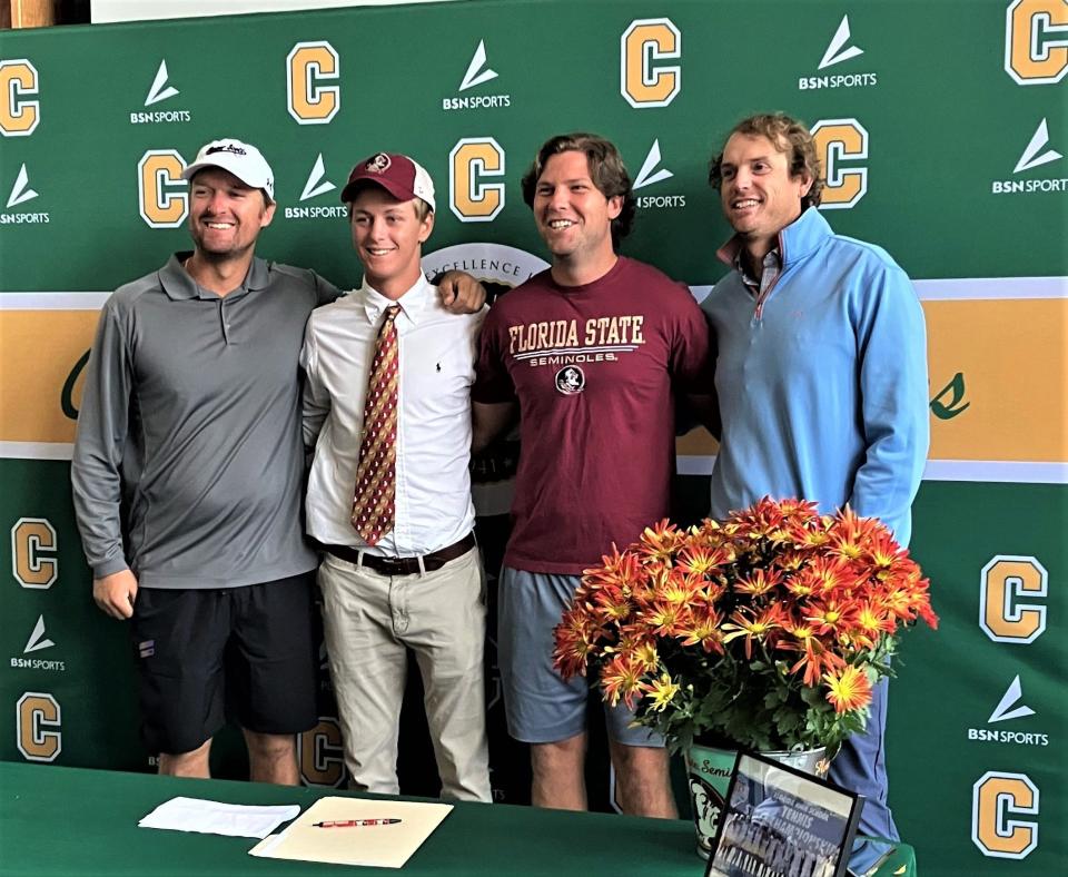 Standing alongside pro coaches Patrick Bateman (far left), Pedro Roese (second from the right) and Brock Sakey (far right), Pensacola Catholic senior Justin Lyons (second from the left) poses for photos after signing his letter of intent to play tennis for Florida State University on Thursday, Nov. 10, 2022 from the Pensacola Catholic High School media center.