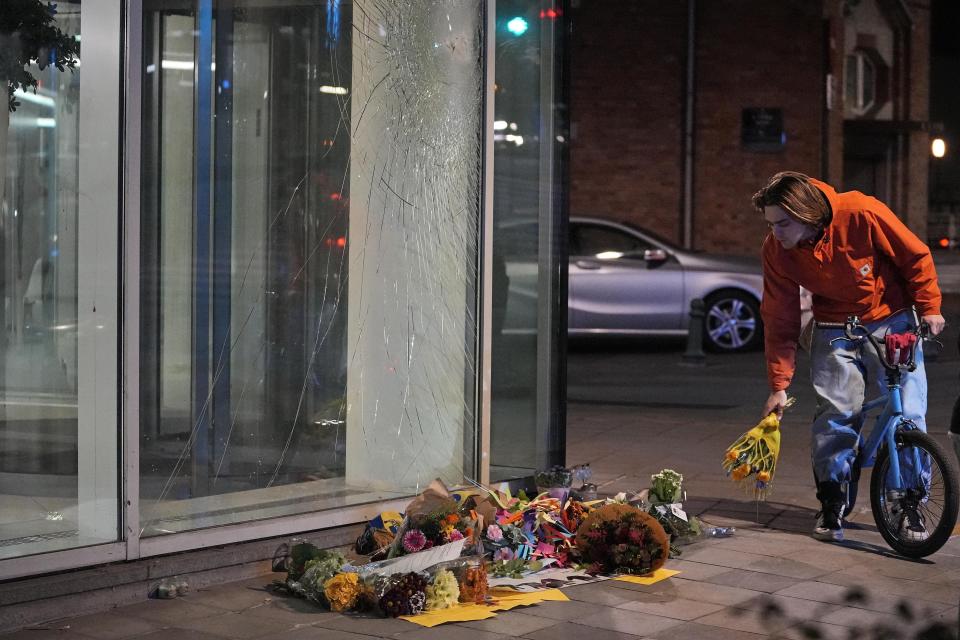 Flowers laid in tribute outside an office building in Brussels, Tuesday evening, Oct. 17, 2023, close to where two Swedish soccer fans were shot by a suspected Tunisian extremist on Monday night. Police in Belgium have shot dead a suspected Tunisian extremist accused of killing two Swedish soccer fans in a brazen attack on a Brussels street before disappearing into the night on Monday. (AP Photo/Martin Meissner)