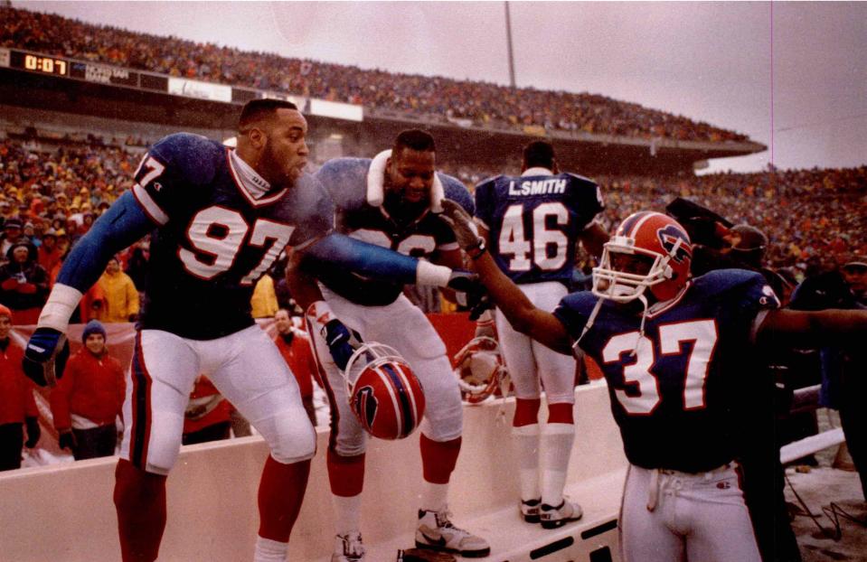 Buffalo Bills Cornelius Bennett (97), Leon Seals (96) and Nate Odomes (37) celebrate their 44-34 victory over the Miami Dolphins with 7 seconds remaining in the game.