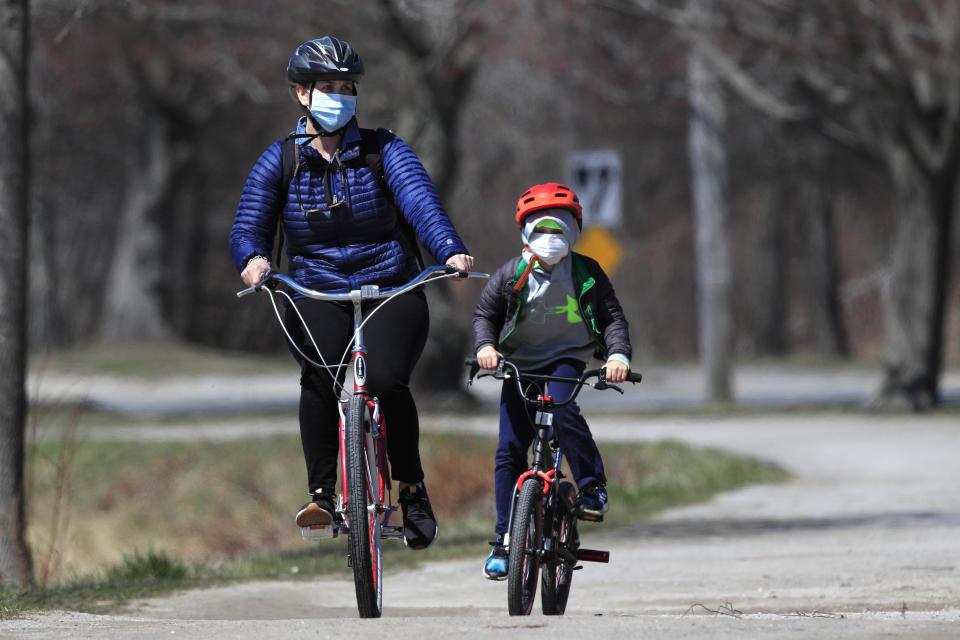FILE-In this Wednesday, April 8, 2020, photo, bicyclists wear pandemic masks while riding in Portland, Maine. Bicycle sales have surged as shut-in families try to find a way to keep kids active at a time of lockdowns and stay-at-home orders during the coronavirus pandemic. (AP Photo/Robert F. Bukaty)