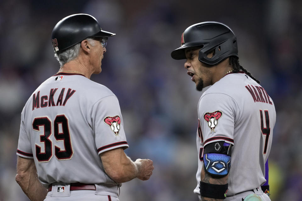 El dominicano Ketel Marte, de los Diamondbacks de Arizona, festeja con el coach de la inicial DAve McKay tras conectar un sencillo de dos carreras ante los Rangers de Texas, en el segundo juego de la Serie Mundial, el sábado 28 de octubre de 2023, en Arlington (AP Foto/Godofredo A. Vásquez)