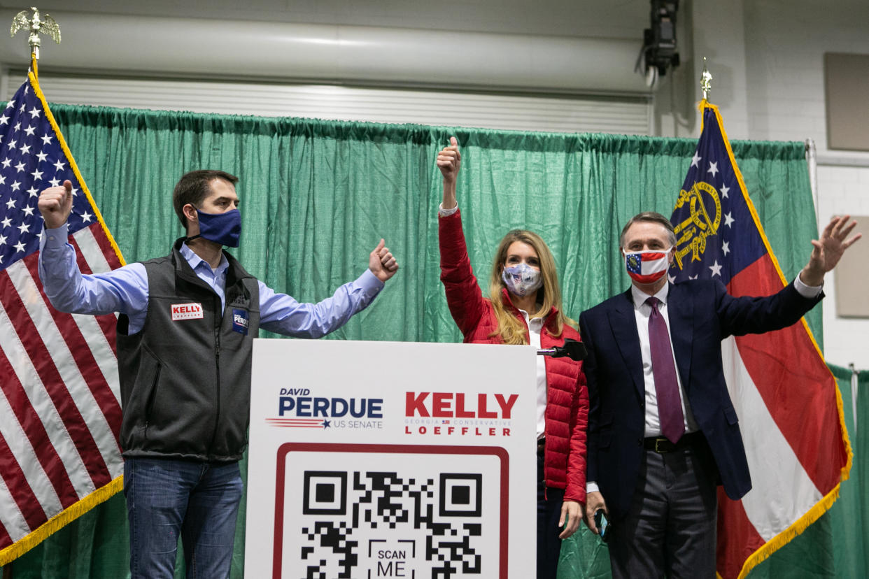 David Purdue and Kelly Loeffler wave to the crowd of supporters at a "Defend the Majority" rally with Sen. Tom Cotton (R-AR). (Photo by Jessica McGowan/Getty Images)