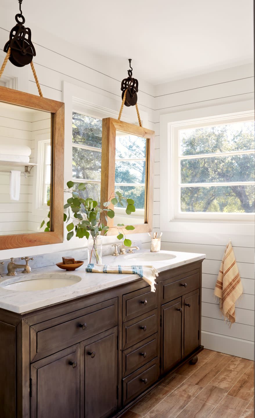 farmhouse bathroom with mirrors hung from old pulleys