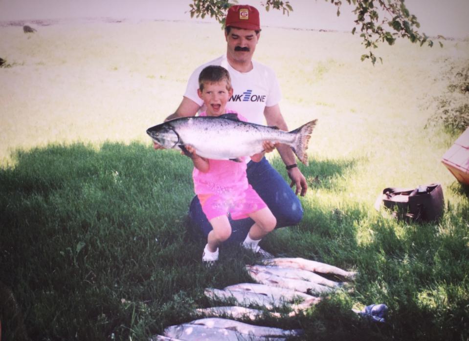 A young Joe Thomas poses with his father, Eric, after a Lake Michigan fishing trip for trout and salmon about 1990.