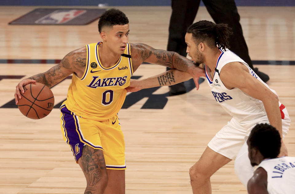 Los Angeles Lakers' Kyle Kuzma (0) is defended by Los Angeles Clippers' Amir Coffey (7) during the third quarter of an NBA basketball game Thursday, July 30, 2020, in Lake Buena Vista, Fla. (Mike Ehrmann/Pool Photo via AP)