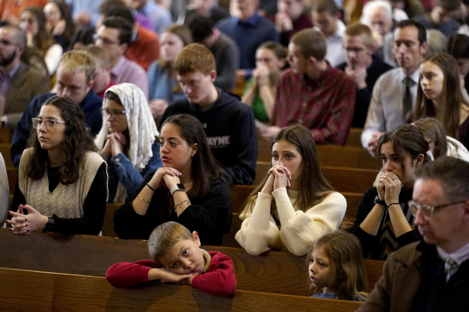 Catholics pray during Mass at Benedictine College Sunday, Dec. 3, 2023, in Atchison, Kan. (AP Photo/Charlie Riedel)