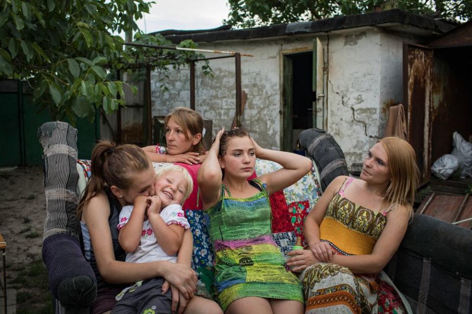 Aleksandra Mountyan, Miroslava Grinik, Olga Grinik, Victoria Mountyan and Valentina Mountyan—all members of an extended family—hang out in the backyard of Olga’s house, located 50 meters from a Ukrainian military position in old Avdeevka. People may appear relaxed to the sounds of shelling and gunfire, but it’s an illusion: they listen to determine the degree of danger. Everyone knows the safest place in their home.