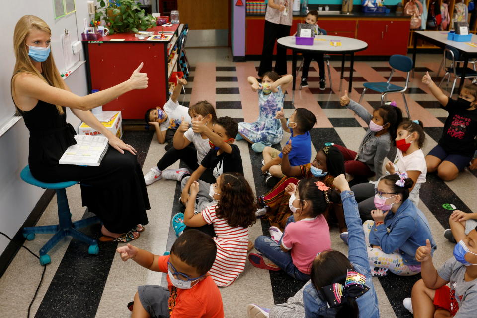 Teacher Emma Rossi works with her first-grade students in September at the Sokolowski School in Chelsea, Mass., where students and teachers are required to wear masks.