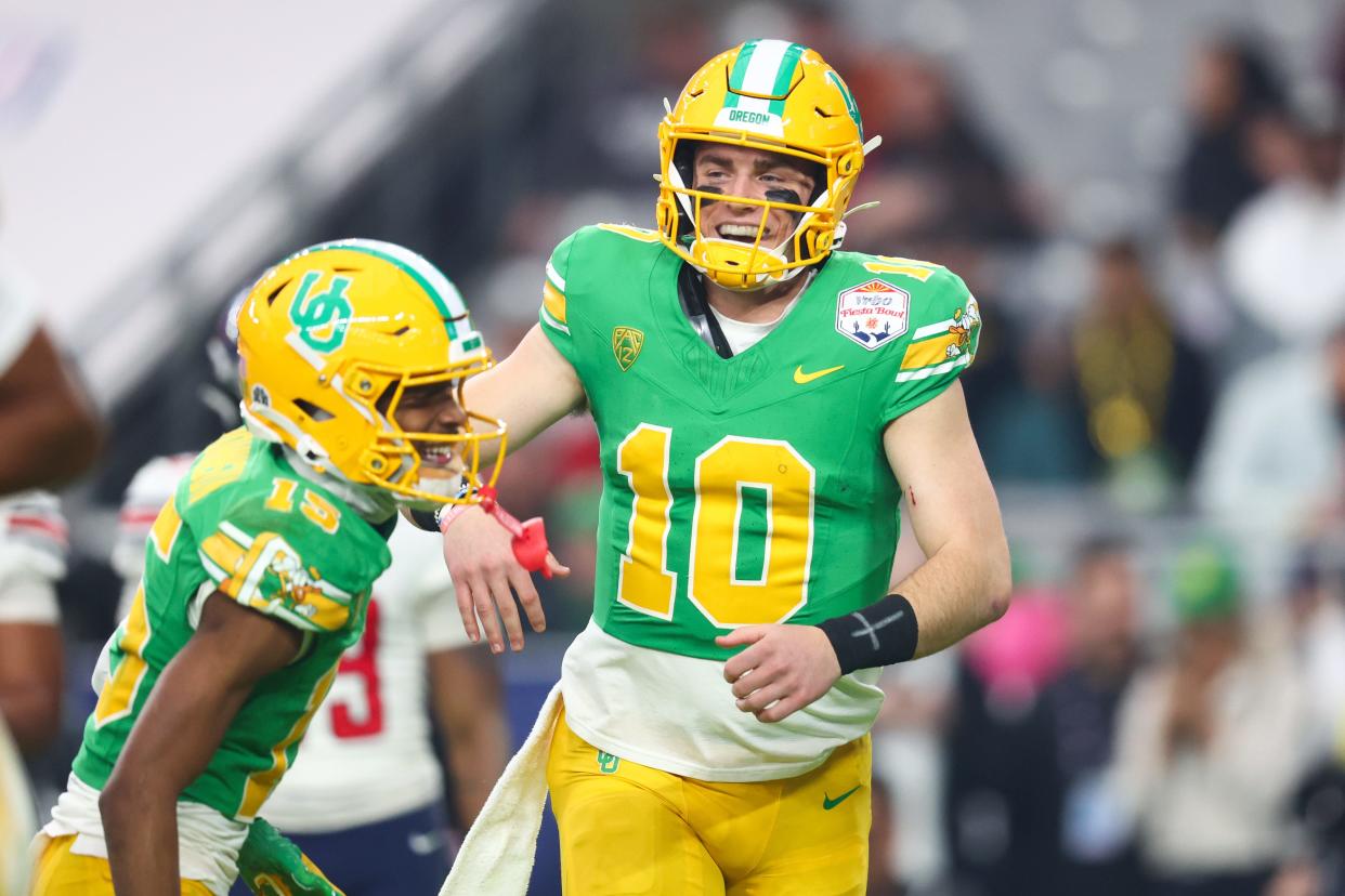 Oregon Ducks quarterback Bo Nix (10) celebrates a touchdown with wide receiver Tez Johnson (15) during the second half against the Liberty Flames in the 2024 Fiesta Bowl at State Farm Stadium.