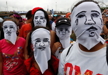 Activists wear hoods depicting families of victims killed in President Rodrigo Duterte's drug war as Duterte delivers his State of the Nation address in Quezon city, Metro Manila, in Philippines July 23, 2018. REUTERS/Erik De Castro