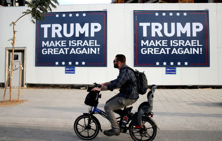 A man cycles past signs bearing the name of U.S. President-elect Republican Donald Trump in Tel Aviv, Israel November 14, 2016. REUTERS/Baz Ratner