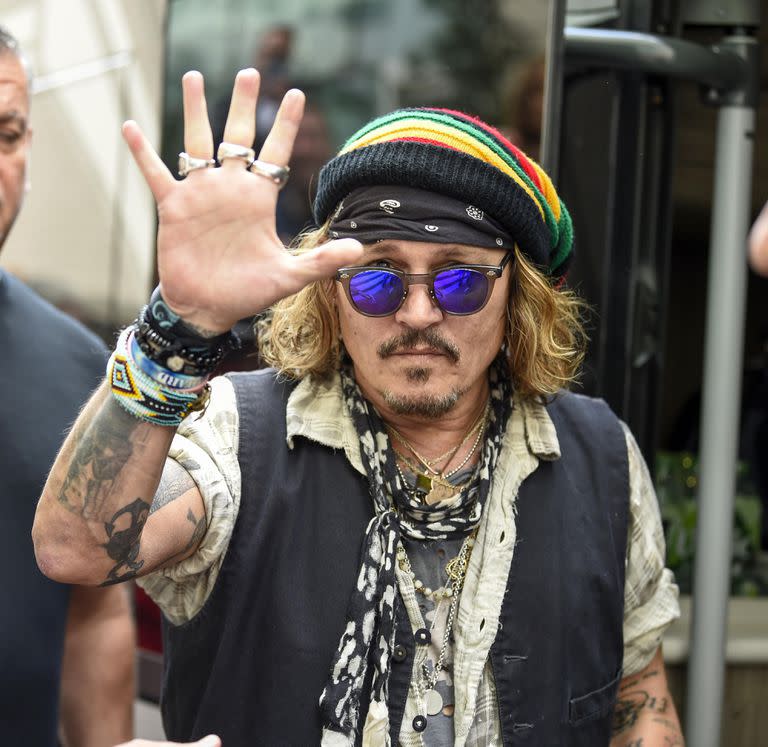 Depp firma autógrafos y posa con fans cuando sale de su hotel en Manchester