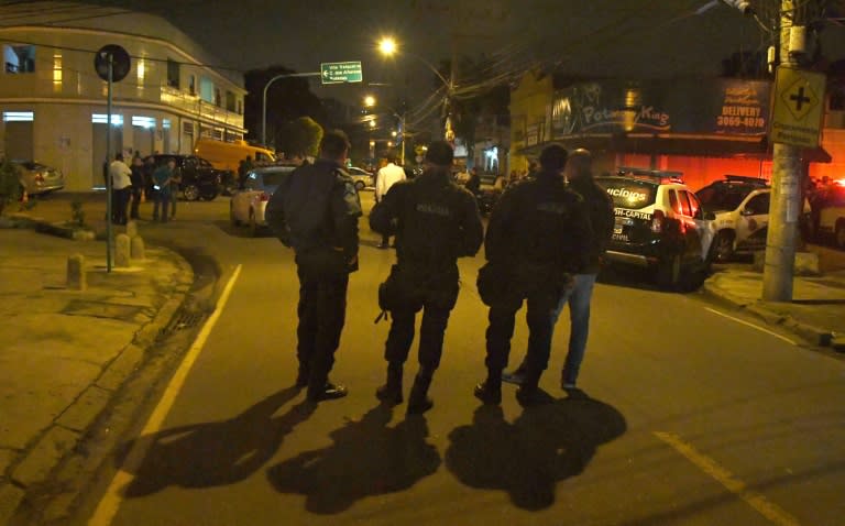 Police guard the scene where municipal candidate Marcos Vieira de Souza, nicknamed Falcon, was murdered while campaigning for the rightwing Progressive Party in Madureira