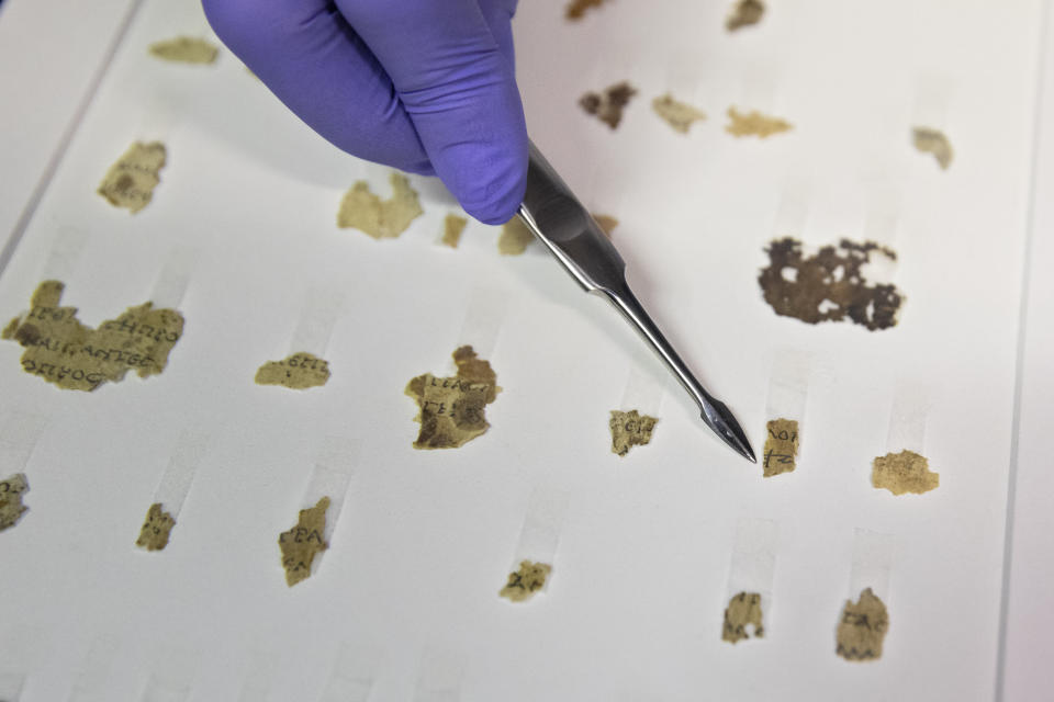 Israel Antiquities Authority conservator Tanya Bitler shows newly discovered Dead Sea Scroll fragments at the Dead Sea scrolls conservation lab in Jerusalem, Tuesday, March 16, 2021. Israeli archaeologists on Tuesday announced the discovery of dozens of new Dead Sea Scroll fragments bearing a biblical text found in a desert cave and believed hidden during a Jewish revolt against Rome nearly 1,900 years ago. (AP Photo/Sebastian Scheiner)