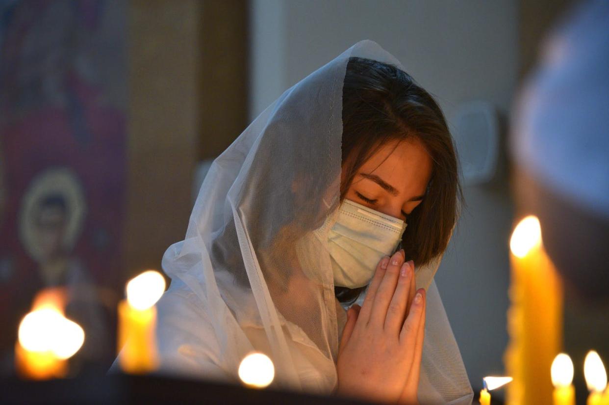 <span class="caption">Has COVID-19 strengthened people's faith?</span> <span class="attribution"><a class="link " href="https://www.gettyimages.com/detail/news-photo/an-armenian-woman-wearing-a-face-mask-prays-in-a-church-in-news-photo/1229123021?adppopup=true" rel="nofollow noopener" target="_blank" data-ylk="slk:Karen Minasyan/AFP via Getty Images;elm:context_link;itc:0;sec:content-canvas">Karen Minasyan/AFP via Getty Images</a></span>