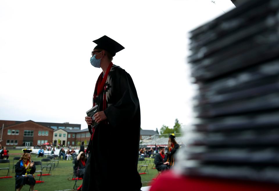 A stack of diplomas sits on a table as North Salem High School graduates walk across the stage during the ceremony on Friday, June 11, 2021, in Salem.