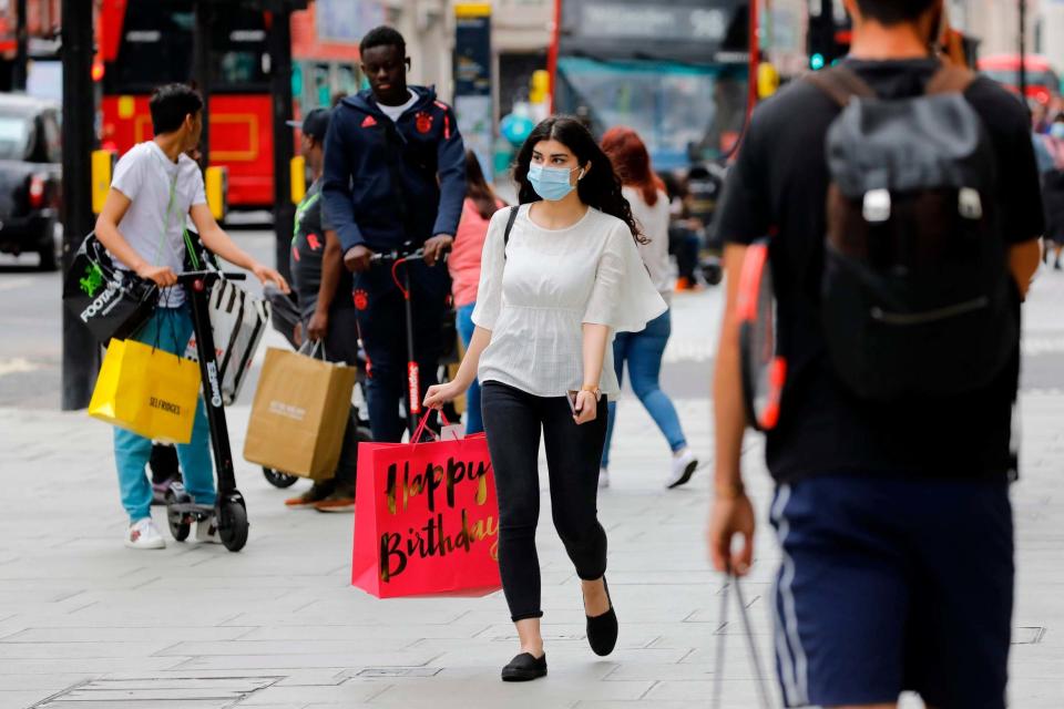 <p>A shopper wears a face mask on Oxford Street</p> (AFP via Getty Images)