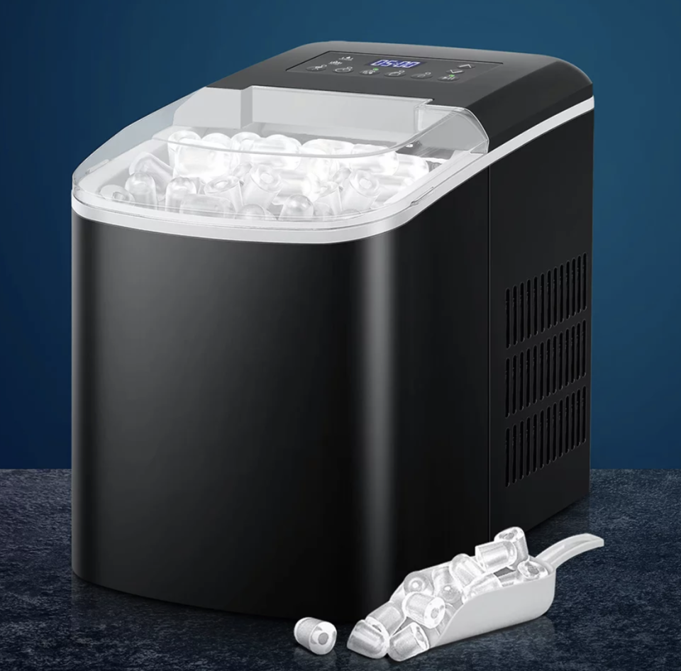 A large black 2.1l Ice Maker Machine with ice visible through the transparent lid and an ice scoop with ice on the bench.