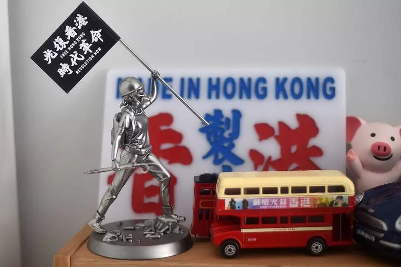 A 'Free Hong Kong Revolution Now' flag on the couple's mantlepiece. Displaying such a slogan in HK itself risks a prison sentence -Credit:Manchester Evening News